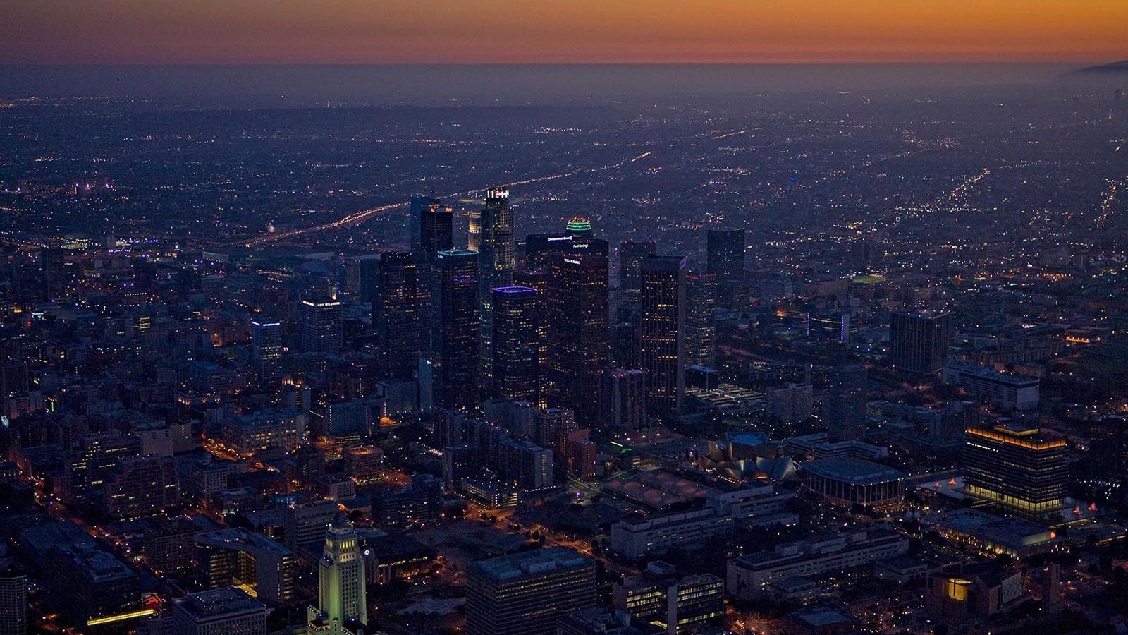 Aerial cityscape of the Downtown Los Angeles Skyline at night, just as the sun goes down