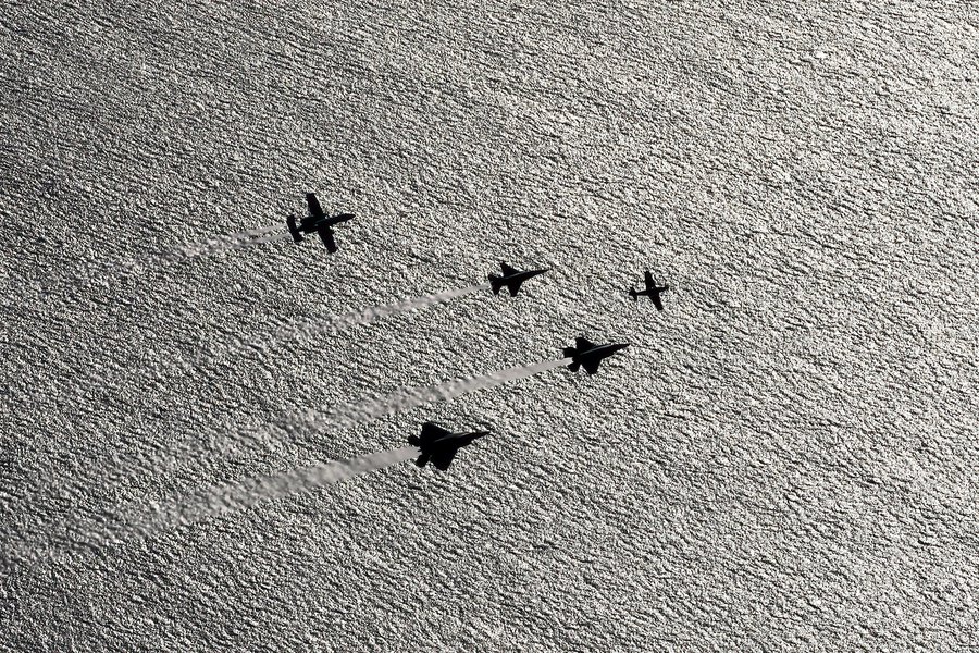 Blog photograph showing silhouettes of an F-22, F-35, P-51, F-16 and A-10 practicing a formation as part of the Air Force Heritage Flight, which will fly over the Super Bowl LVI game