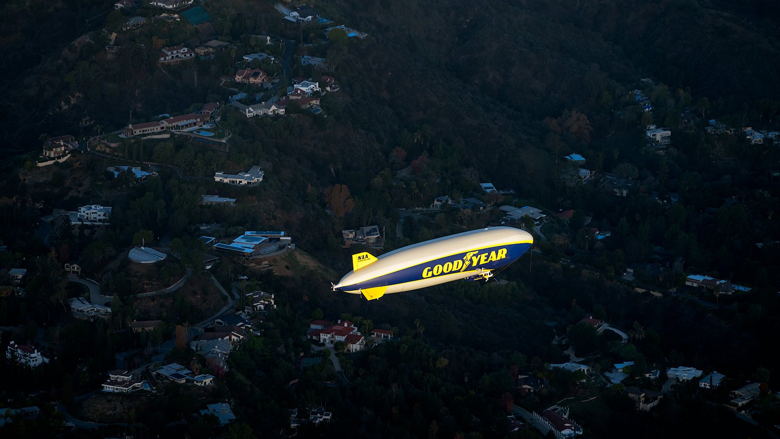 Blog photograph of the Goodyear Blimp flying over a residential neighborhood on January 1st 2022