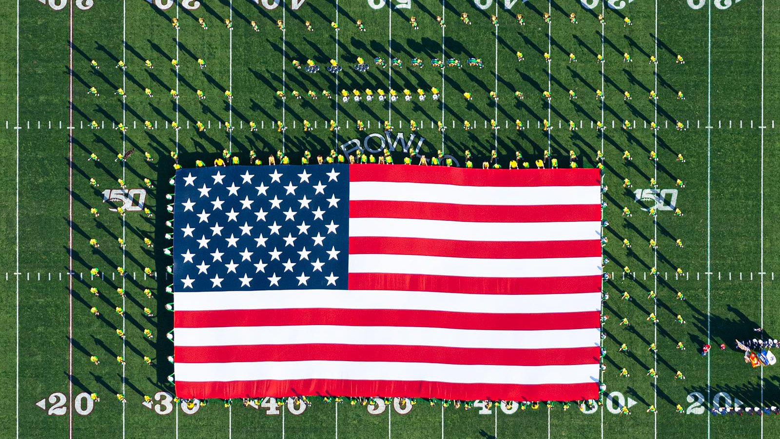 Blog image of the Oregon Marching Band (OMB) holding an American Flag on the field of the 106th Rose Bowl Game