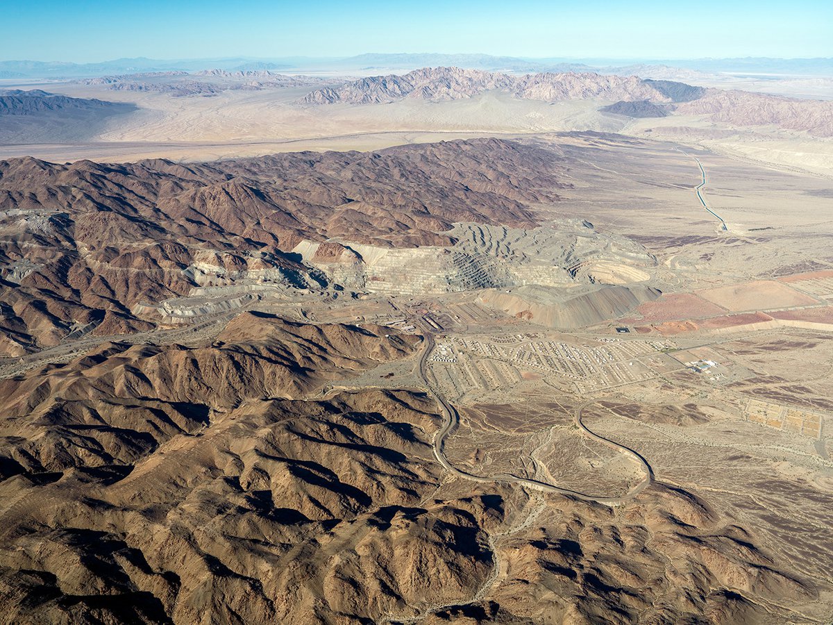 A panoramic aerial view of the Eagle Mountain ghost town and the now-defunct iron mine, a stark contrast of desolation and natural beauty.