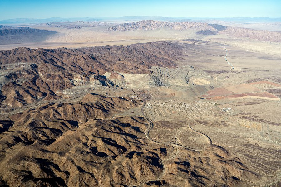 A panoramic aerial view of the Eagle Mountain ghost town and the now-defunct iron mine, a stark contrast of desolation and natural beauty.