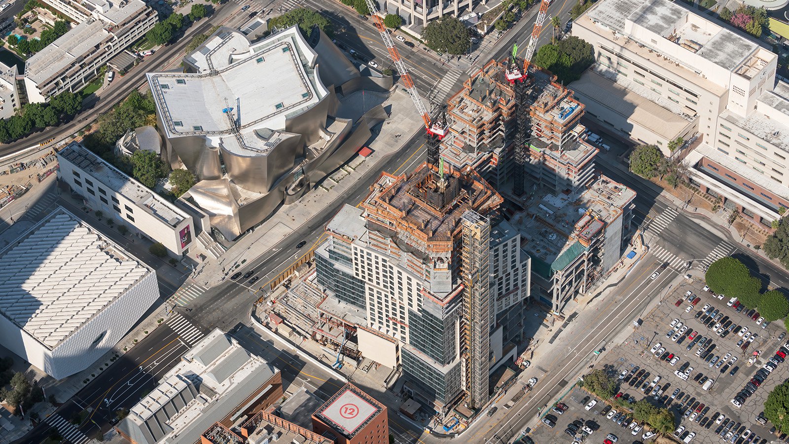 Aerial blog photo of two tall cranes climbing higher and higher and more and more floors are completed during construction of The Grand in Downtown Los Angeles, California