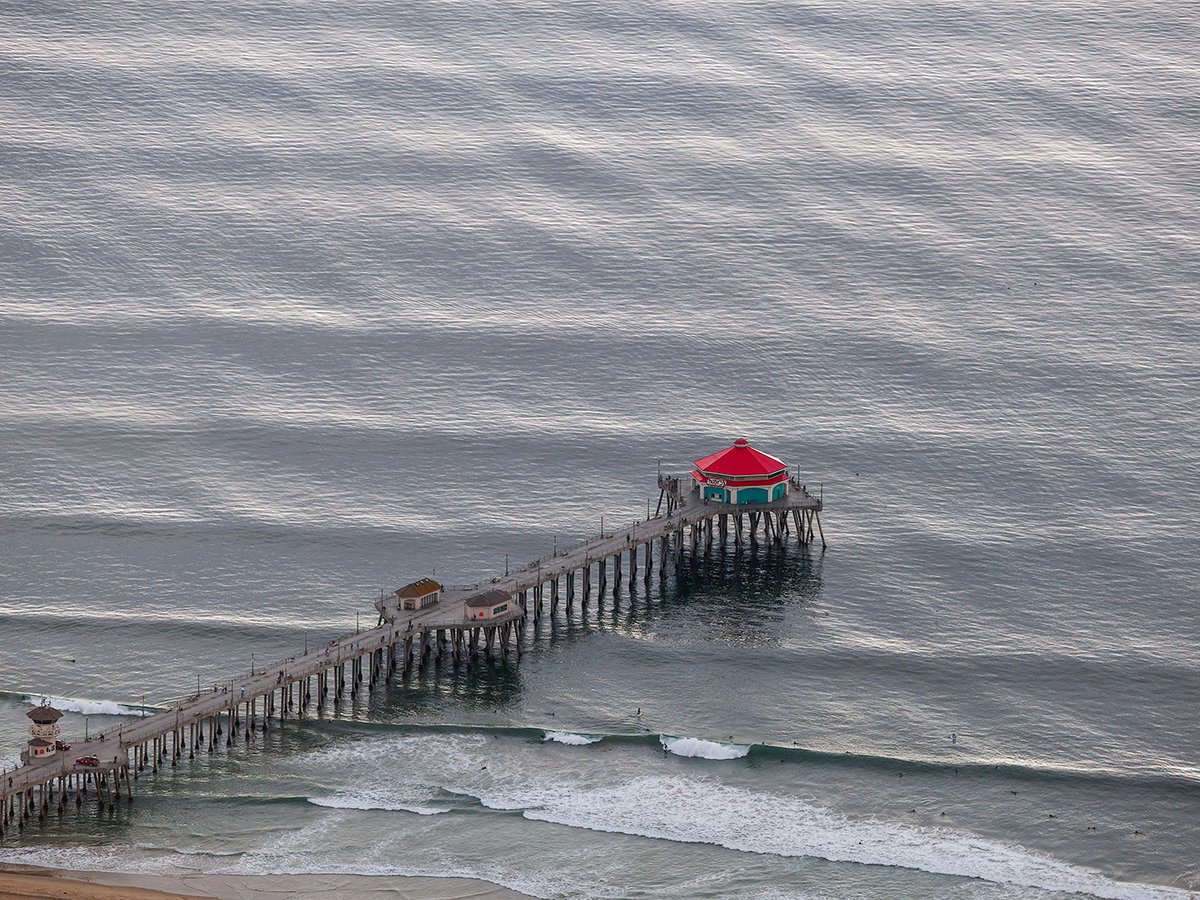 Blog photo of the Huntington Beach Pier on a day with a southern swell and many surfers in the water in Huntington Beach, California