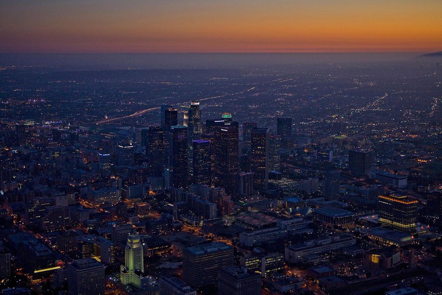 Aerial cityscape of the Downtown Los Angeles Skyline at night, just as the sun goes down