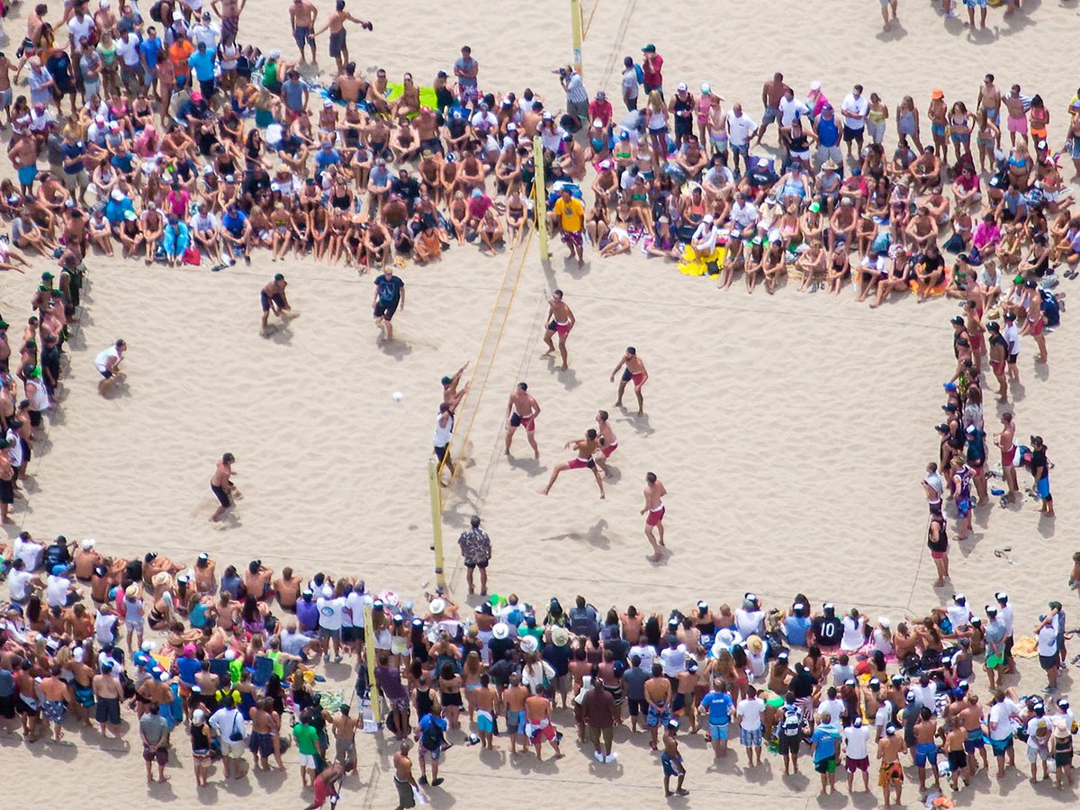 Blog photo of a volleyball player spiking the ball during the Charlie Saikley six man beach volleyball tournament in Manhattan Beach, California