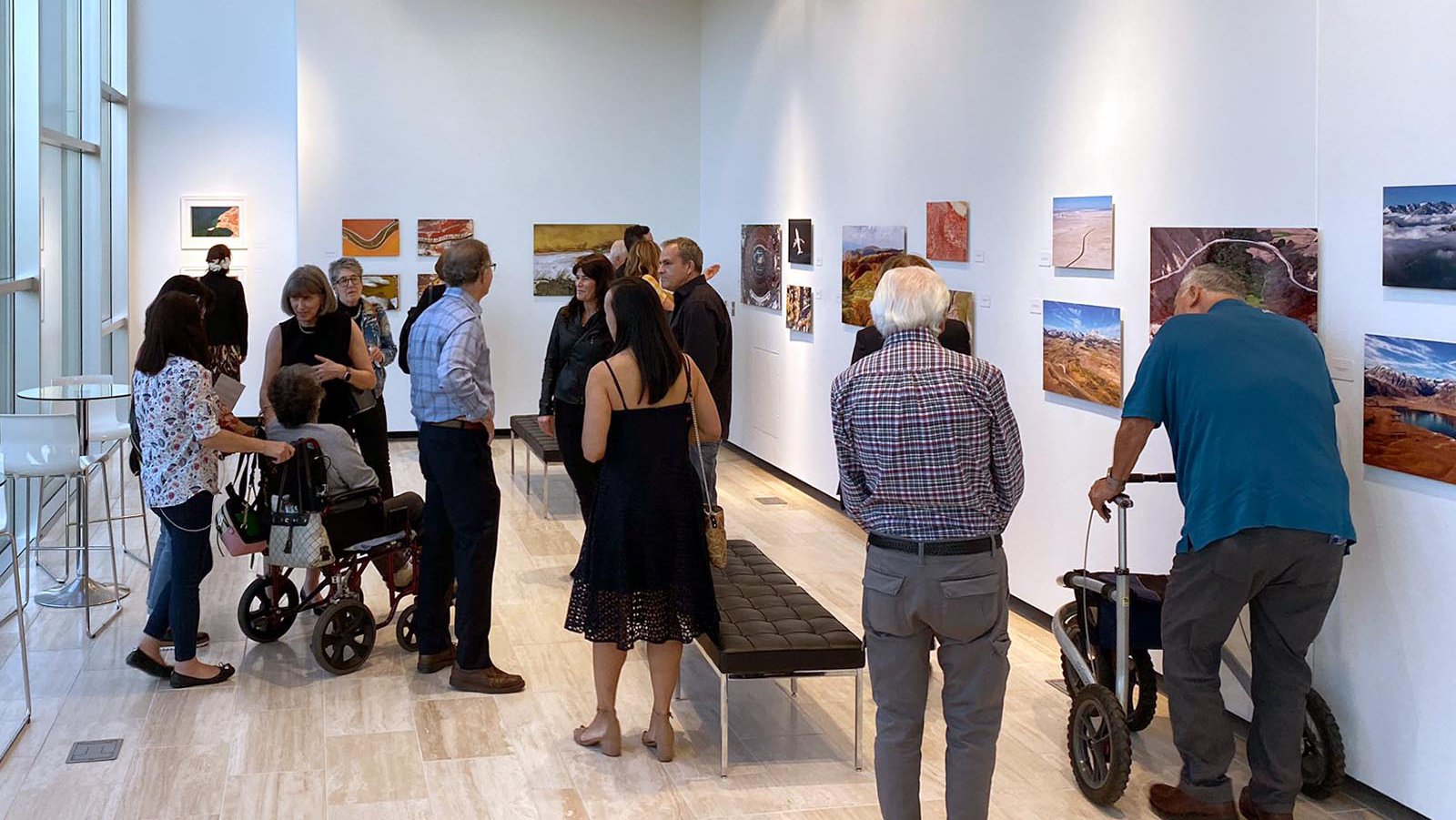 Guests view photographs during Mark Holtzman's solo photography exhibition at the Soraya Art Gallery at CSUN in Northridge, California