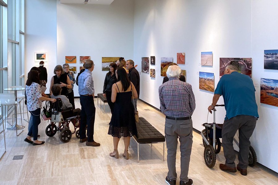 Guests view photographs during Mark Holtzman's solo photography exhibition at the Soraya Art Gallery at CSUN in Northridge, California