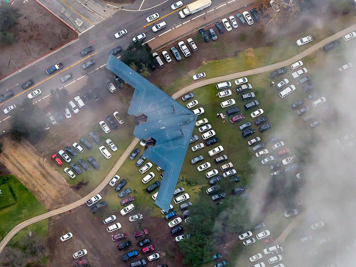 Blog image of the B-2 Stealth Bomber emerging from between the clouds over the Rose Bowl Stadium in Pasadena, California