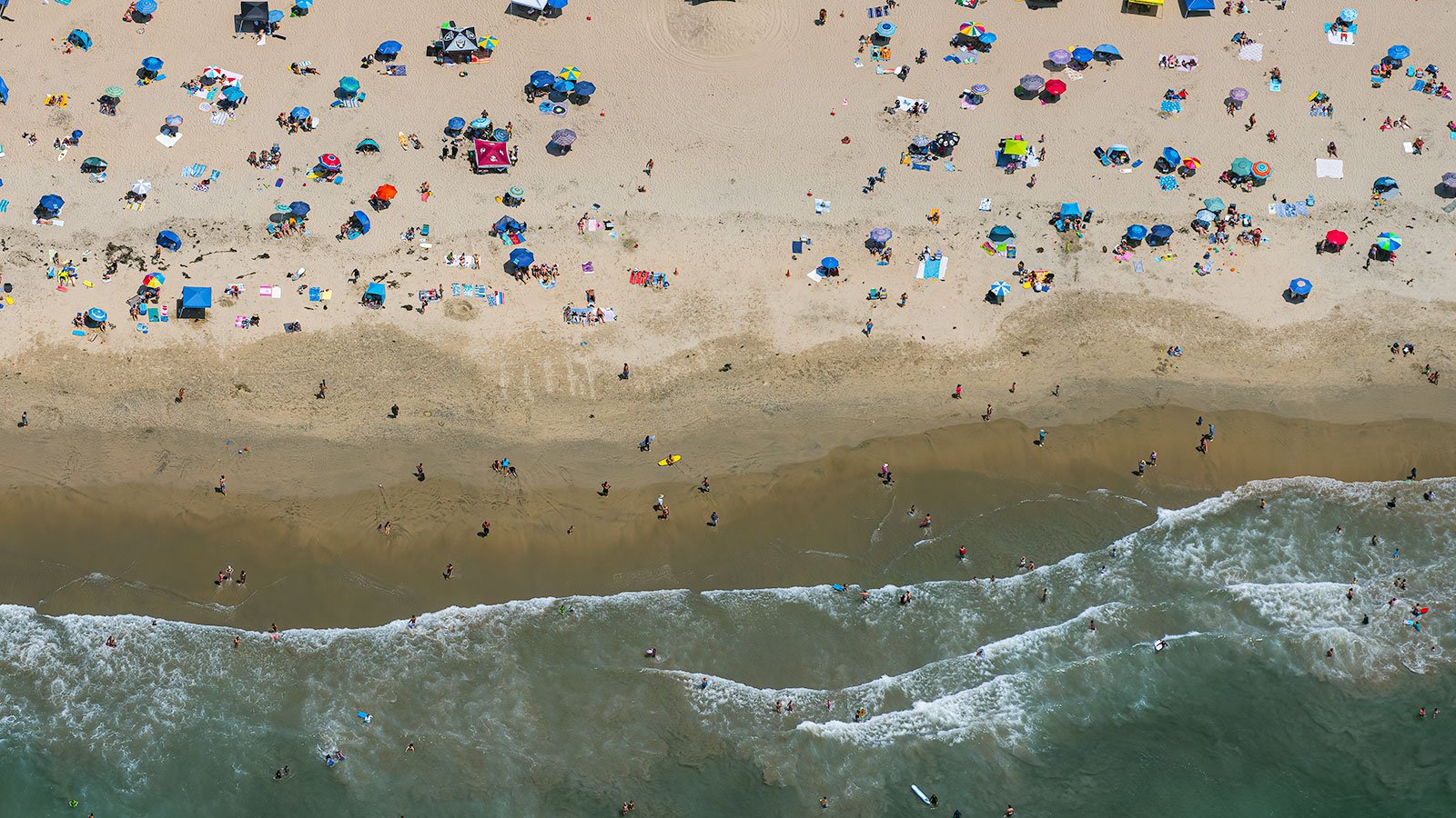 Close-up blog photo of beach goers escaping the heat and enjoying the summer weather at the beach in Huntington Beach, California