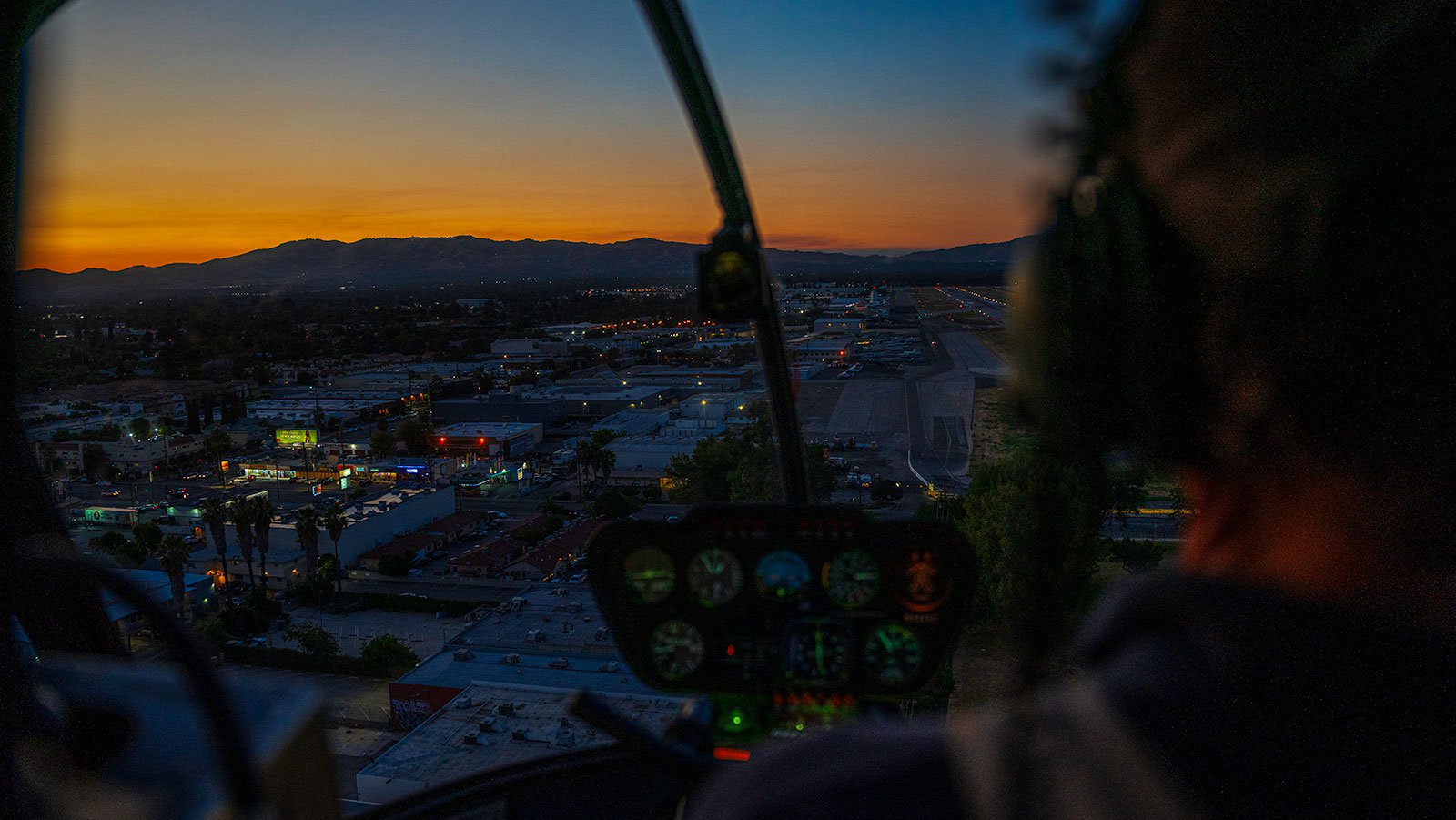 Blog image of cockpit view over Van Nuys, California, during sunset helicopter flight