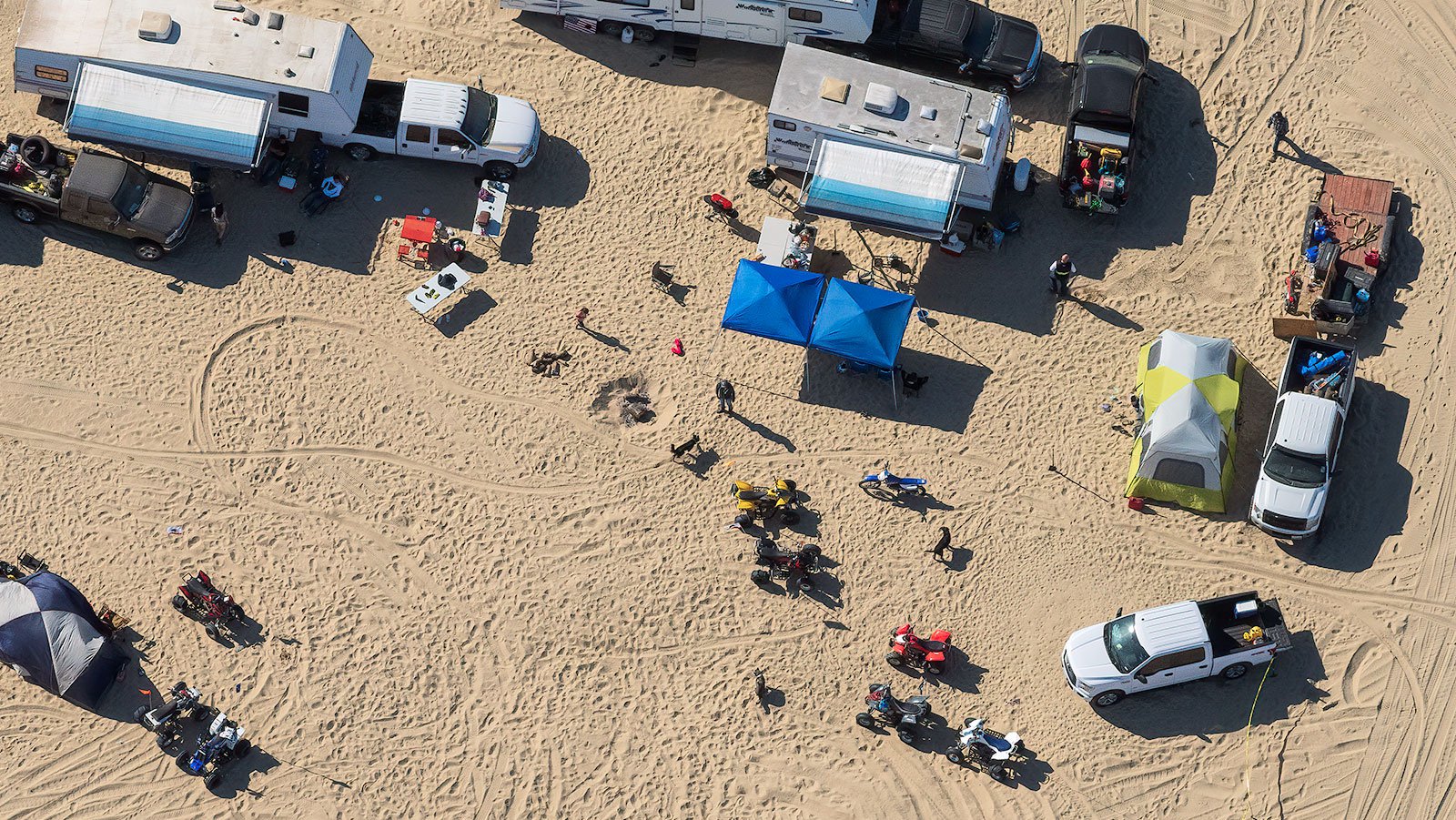 Blog image of thrillcraft owners with quads, pickups, tents and RVs making camp at the Oceano Dunes Vehicular Recreation Area near Pismo Beach, California