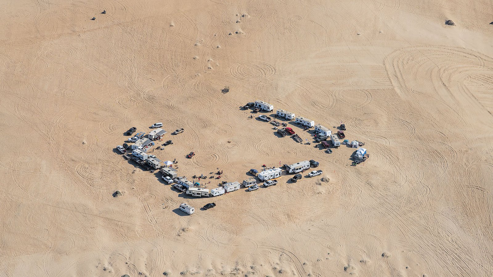 Blog photograph of many RVs make camp and prepare their off-road vehicles for a weekend on the Oceano Dunes near Pismo Beach, California