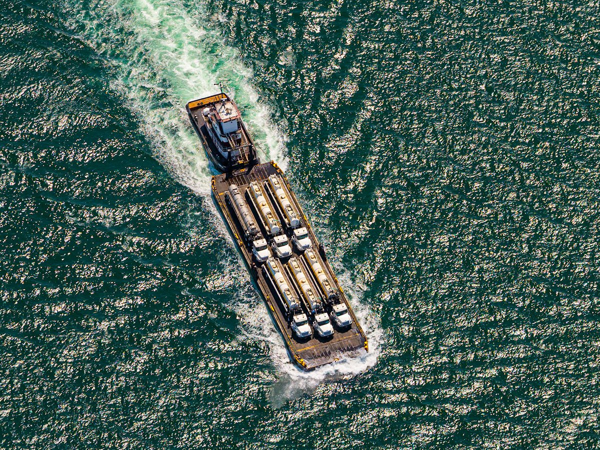 Blog photo of a tug boat pushing a barge of fuel trucks at Americas Port in San Pedro, California