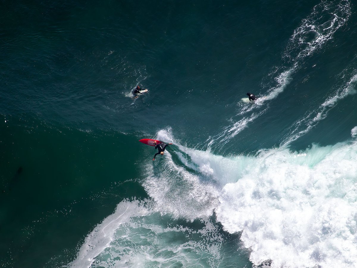 Blog image of a surfer in Malibu, California taking advantage of the big surf swells